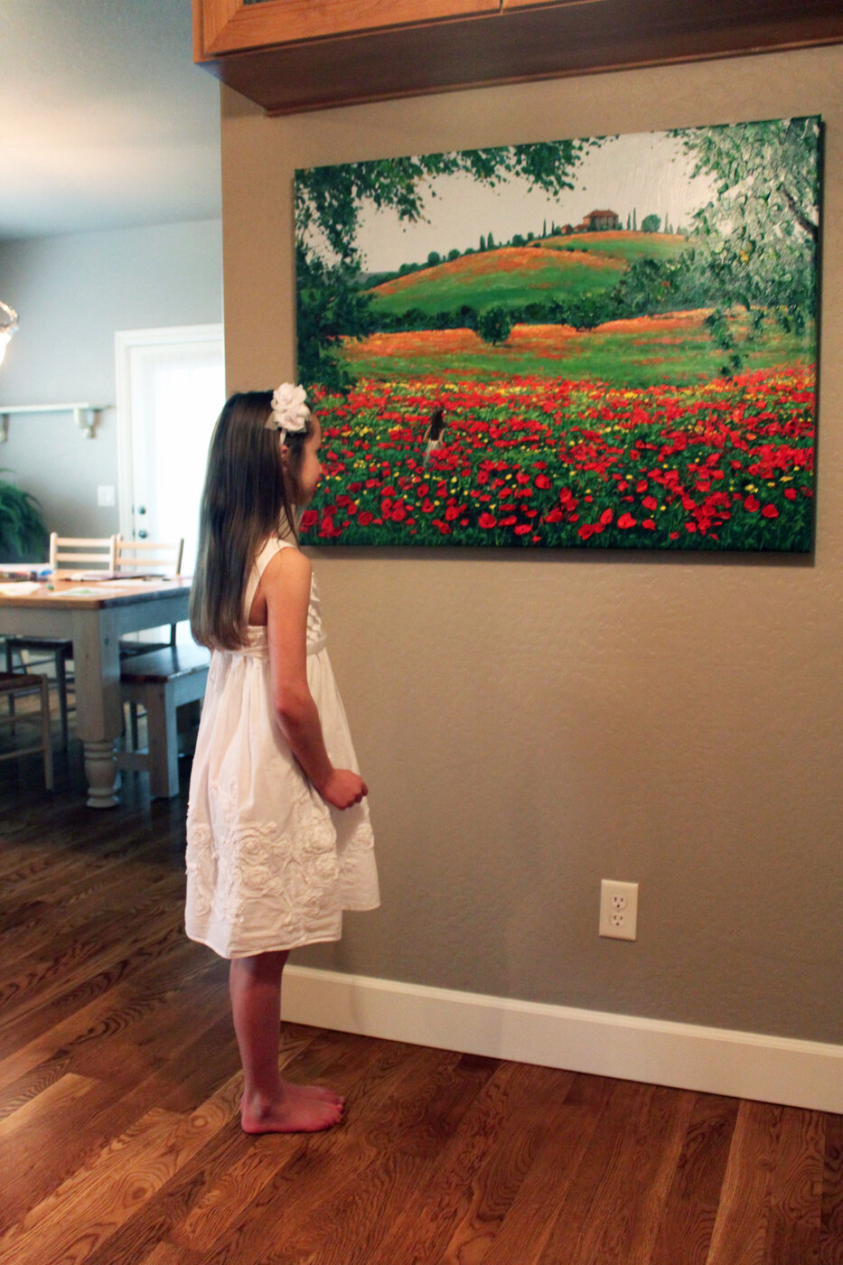 Clara with a poppy painting at home