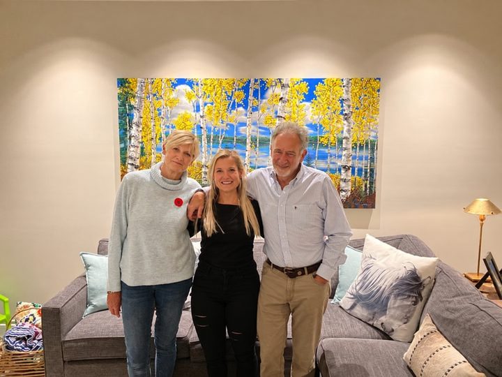Jen with Jill and Howie in front of Content hanging in their home